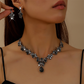 Set med halsband och örhängen med glittrande droppformade hängsmycken